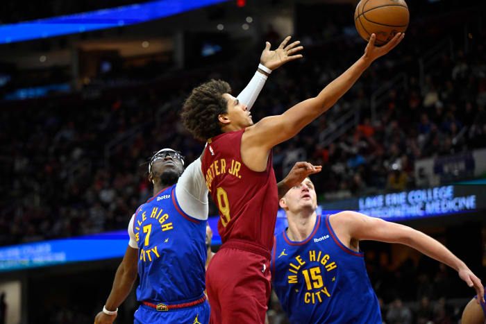 Nov 19, 2023; Cleveland, Ohio, USA; Cleveland Cavaliers guard Craig Porter (9) drives against Denver Nuggets guard Reggie Jackson (7) and center Nikola Jokic (15) in the fourth quarter at Rocket Mortgage FieldHouse.